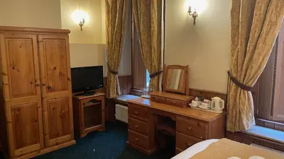 a room with a bedroom with a bed and a mirror at Crown Hotel in Downham Market