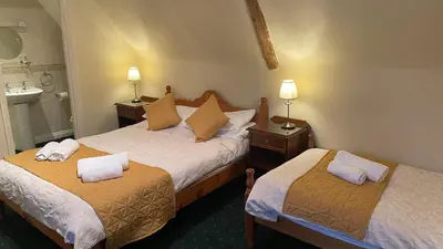 a hotel room with two beds and a sink at Crown Hotel in Downham Market