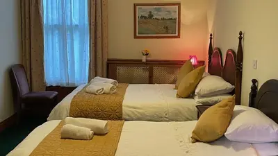 a hotel room with two beds with towels on them at Crown Hotel in Downham Market