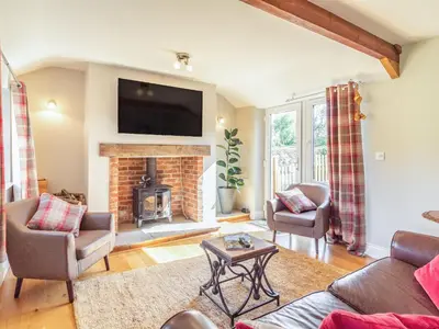 a living room with a fireplace and a tv at The Croft in Thetford