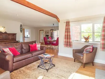 a living room with a brown leather couch and chairs at The Croft in Thetford