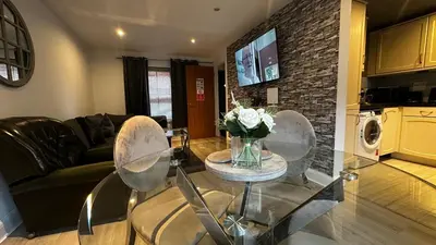 a living room with a glass table with flowers on it at One Bedroom Flat Town Centre Colchester in Colchester