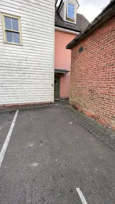 an empty parking lot next to a brick building at One Bedroom Flat Town Centre Colchester in Colchester