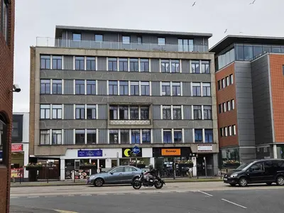 a large building with cars parked in front of it at Modern Town Centre Apartment in Chelmsford