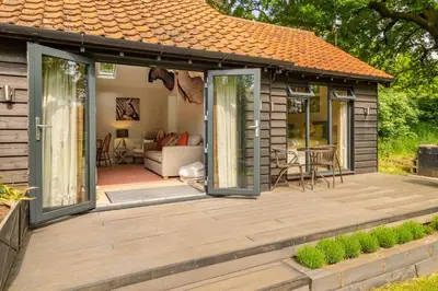 a house with a deck with a living room at The Lodge, Wherstead in Wherstead
