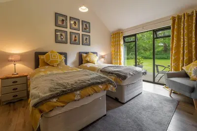 two beds in a bedroom with a window at The Lodge, Wherstead in Wherstead