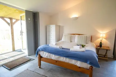 a bedroom with a bed with towels on it at East Green Farm Cottage - Studio Barn - Aldeburgh Coastal Cottages in Kelsale