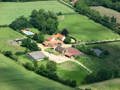 an overhead view of a large house in a field at East Green Farm Cottage - Studio Barn - Aldeburgh Coastal Cottages in Kelsale
