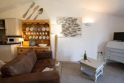 a living room with a couch and a table at East Green Farm Cottage - Studio Barn - Aldeburgh Coastal Cottages in Kelsale