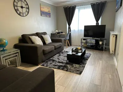 a living room with a couch and a tv at Modern Cosy Warm Home With Free Parking in Chelmsford