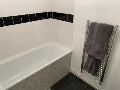 a white bath tub in a bathroom with a towel at Modern Cosy Warm Home With Free Parking in Chelmsford