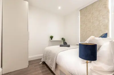 a white bedroom with a bed and a window at Townhouse for Professionals (5 Bedroom 5 Ensuite) in Ipswich