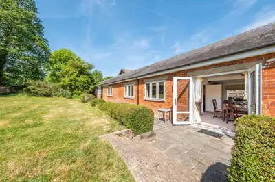a brick house with a patio and a yard at Charming cottage in beautiful countryside with a boating lake - The Calf Pens in Ipswich