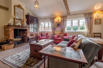 a living room with a couch and a fireplace at Charming cottage in beautiful countryside with a boating lake - The Calf Pens in Ipswich