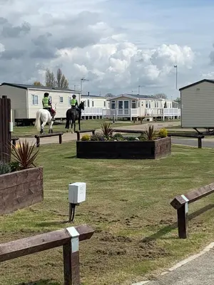 two people are riding horses in a field at DaisyChain Getaways The perfect place to Stay Play and Getaway in East Mersea