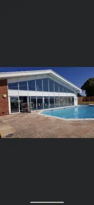 a large building with a swimming pool in front of it at DaisyChain Getaways The perfect place to Stay Play and Getaway in East Mersea