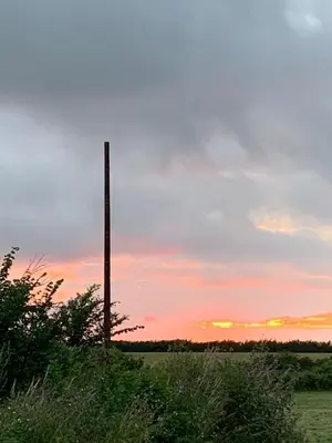 a pole in the middle of a field at sunset at DaisyChain Getaways The perfect place to Stay Play and Getaway in East Mersea