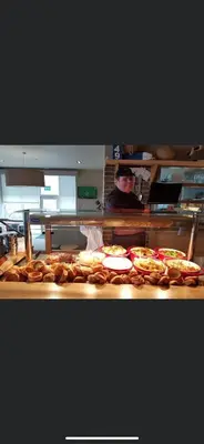 a man standing behind a counter with a bunch of pizzas at DaisyChain Getaways The perfect place to Stay Play and Getaway in East Mersea