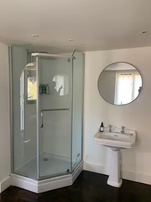 a bathroom with a glass shower and a sink at Bluebell Barn in Banham