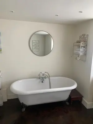 a white bath tub in a bathroom with a mirror at Bluebell Barn in Banham