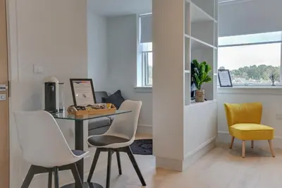 a dining room with a table and chairs at Kings Road Apartments in Brentwood