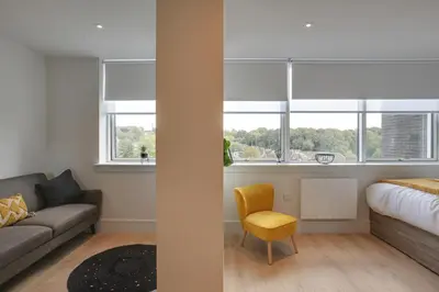 a living room with a couch and two windows at Kings Road Apartments in Brentwood