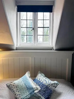two pillows sitting on a bed in front of a window at Charming Annexe in a rural setting in Newton