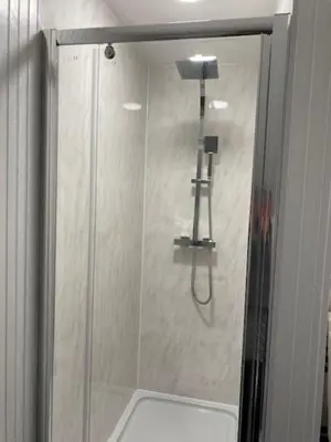 a shower with a glass door in a bathroom at Seaview B&B in Harwich