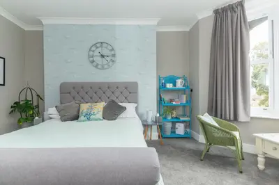 a bedroom with a bed and a clock on the wall at Seaview B&B in Harwich