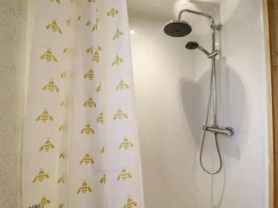 a shower with a shower curtain with a microphone at Buttercup Lodge in Leiston