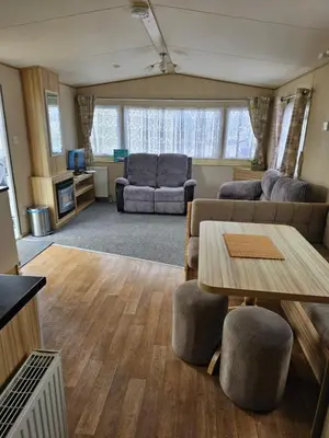 a living room with a couch and a table at Exquisite holidays letting for 3 nights starting from £90 in Jaywick Sands