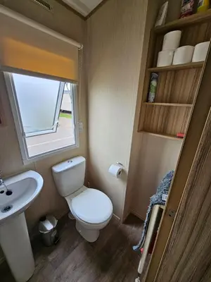 a small bathroom with a toilet and a sink at Exquisite holidays letting for 3 nights starting from £90 in Jaywick Sands