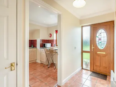 a hallway with a door leading to a kitchen at Orchard Cottage in Saint Osyth