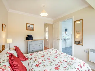 a bedroom with a bed with red pillows at Orchard Cottage in Saint Osyth