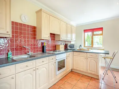 a kitchen with white cabinets and a sink at Dairy Cottage in Saint Osyth
