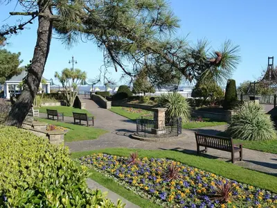 a park with benches and flowers in a park at Willowtree Cottage in Saint Osyth