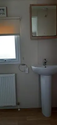 a bathroom with a white sink and a mirror at La Casa Greenaway in Jaywick Sands
