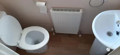 a bathroom with a toilet and a sink at La Casa Greenaway in Jaywick Sands