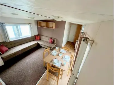 a living room with a table and a couch at La Casa Greenaway in Jaywick Sands