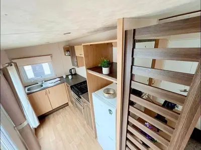a small kitchen with a stove and a refrigerator at La Casa Greenaway in Jaywick Sands