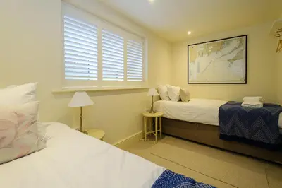 a bedroom with two beds and a window at Drake House in Aldeburgh
