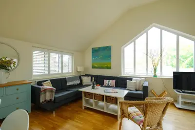 a living room with a couch and a tv at Drake House in Aldeburgh