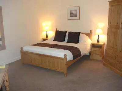 a bedroom with a bed with two night stands and two lamps at The Fox Inn in Matching