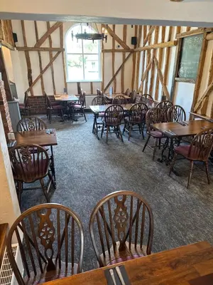 a dining room with wooden tables and chairs at The Fox Inn in Matching