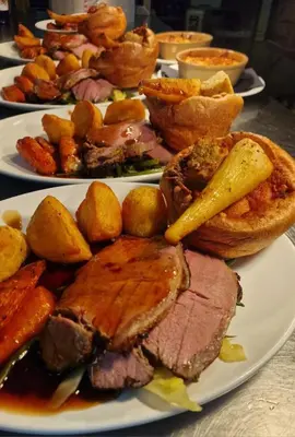 a plate of food with meat and potatoes on a table at The Fox Inn in Matching
