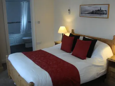 a bedroom with a large bed with red pillows at The Fox Inn in Matching