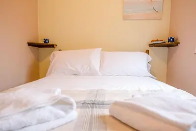 a bedroom with white sheets and pillows on a bed at The Woodshed, Benhall in Saxmundham