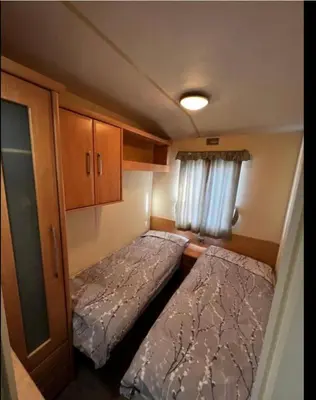 a small room with two beds and a window at Dedham Lodge in Lawford