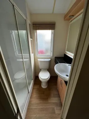 a small bathroom with a toilet and a sink at Dedham Lodge in Lawford