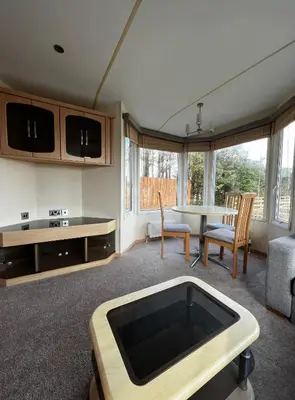a large living room with a table and a couch at Dedham Lodge in Lawford